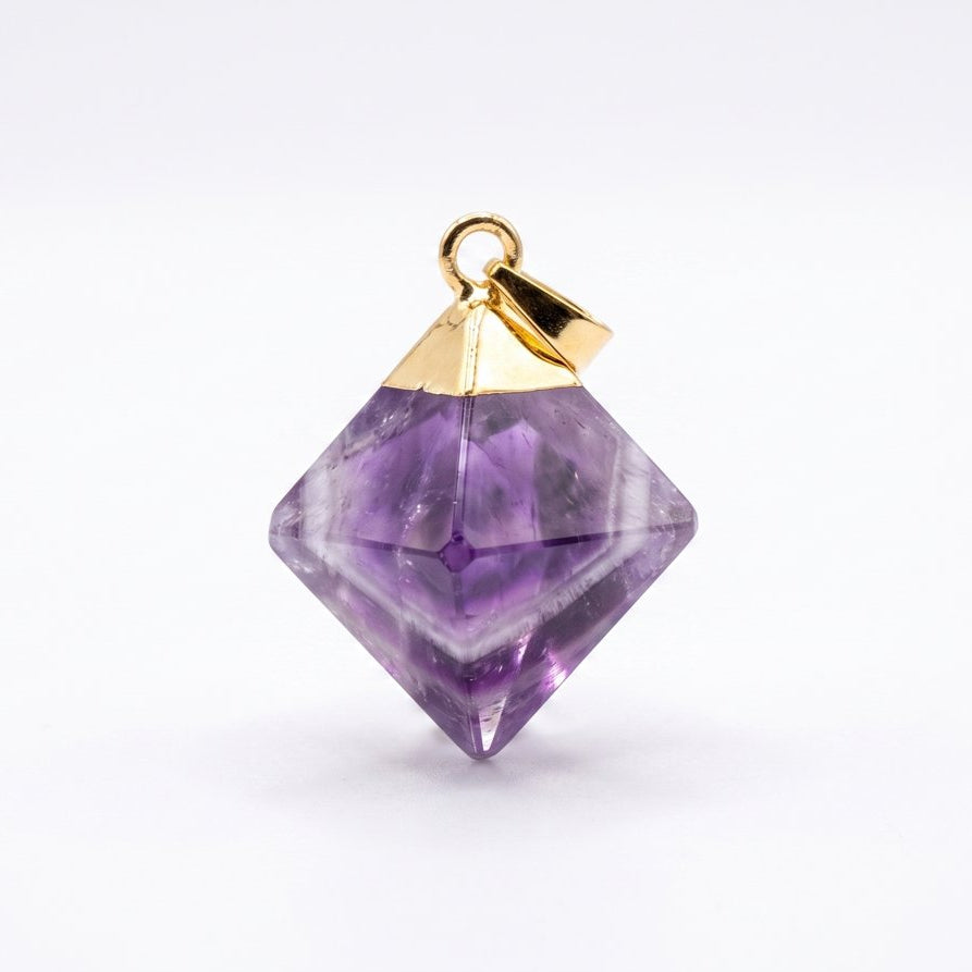 A faceted purple gemstone pendant with a gold metal cap and loop, shown on a clean white background.
